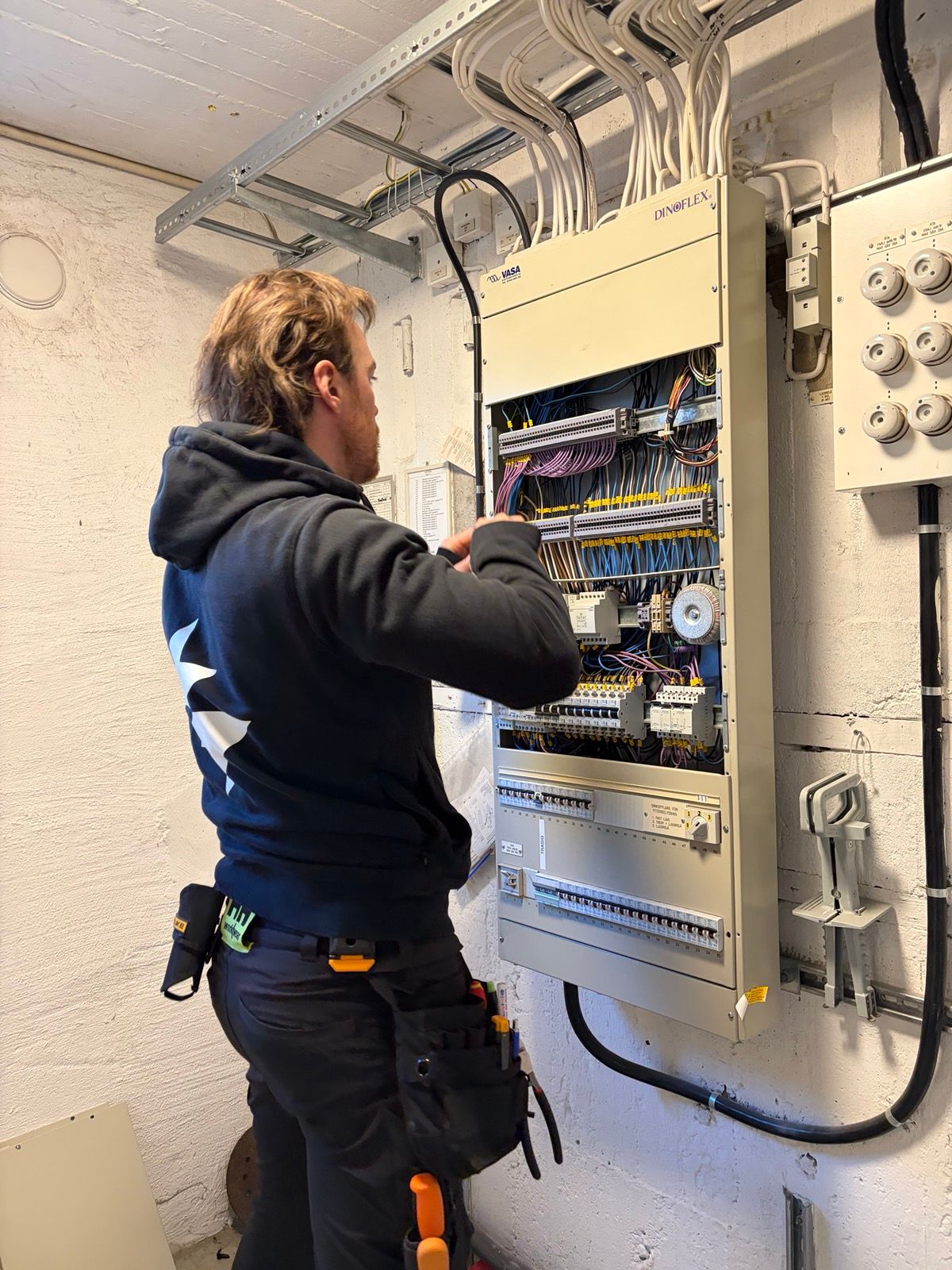 Patrik Lundberg, elektriker och grundare av Sparkon, fokuserad på detaljarbete i ett elskåp