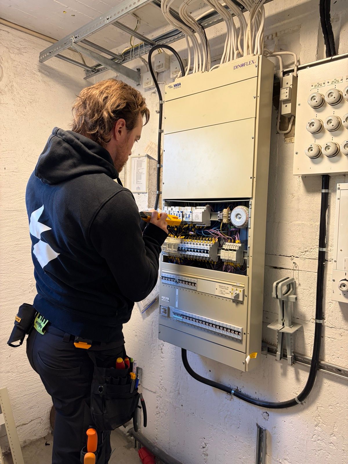 Patrik Lundberg installerar i ett elskåp med tjockt kablage