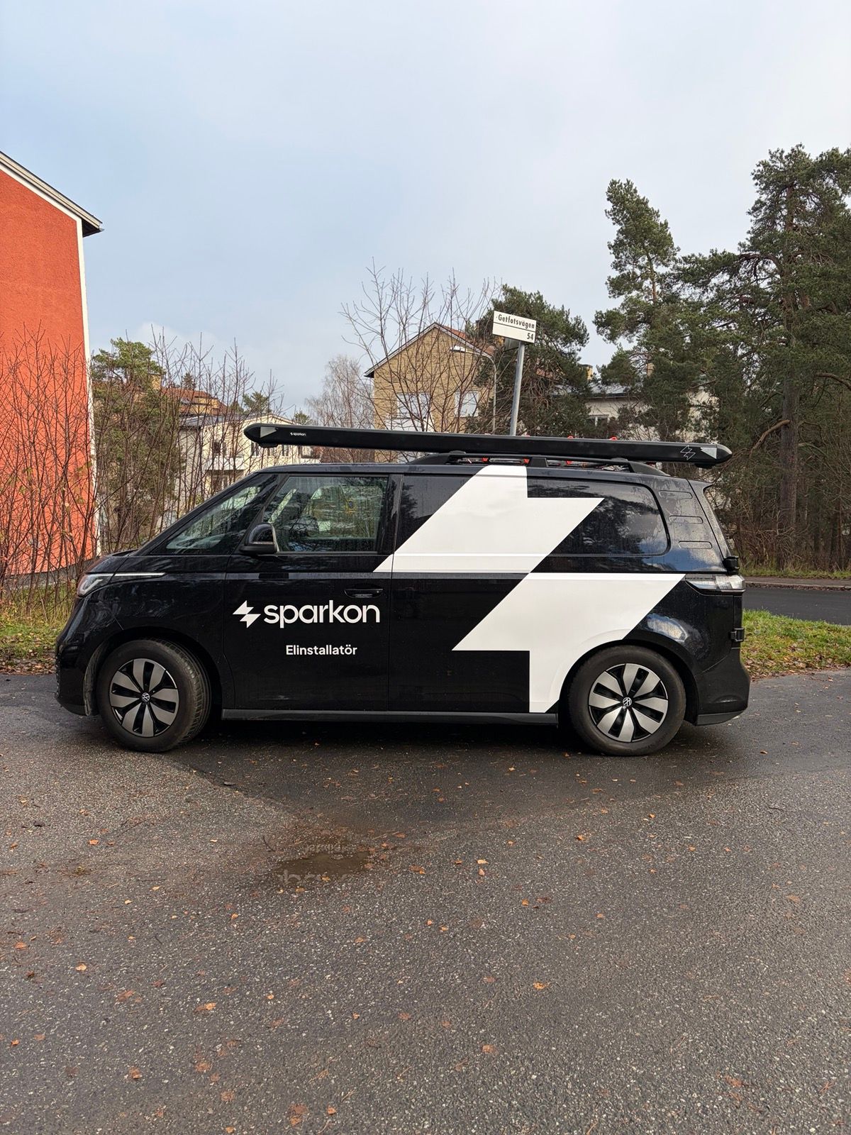 Sparkons servicebil — en svart elektrisk Volkswagen ID. Buzz med Sparkon-symbolen på sidan